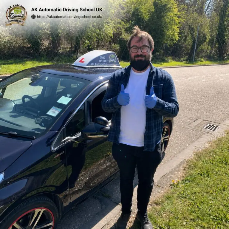 AK Automatic Driving School pupil celebrating with a thumbs up beside the car