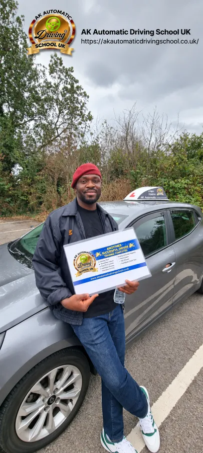 AK Automatic Driving School student holding a training completion sign while leaning on the instructor car