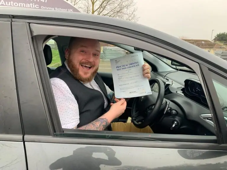 AK Automatic Driving School pupil holding a practical test pass certificate inside the car